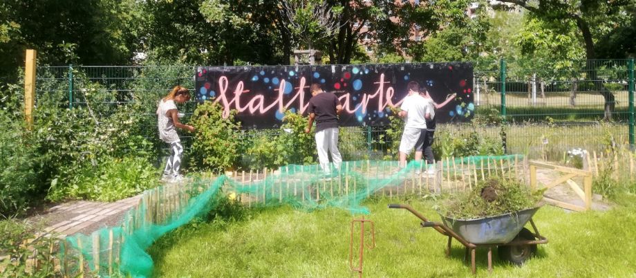 Personen bringen Banner im Garten an den Zaun an 