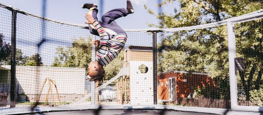Ein Junge macht einen Salto auf einem Trampolin.