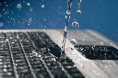 Wasser tropft auf einen Laptop